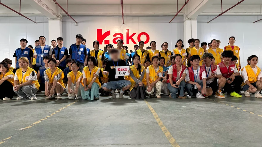 Group photo of the Kakobuy warehouse team in front of the Kakobuy logo